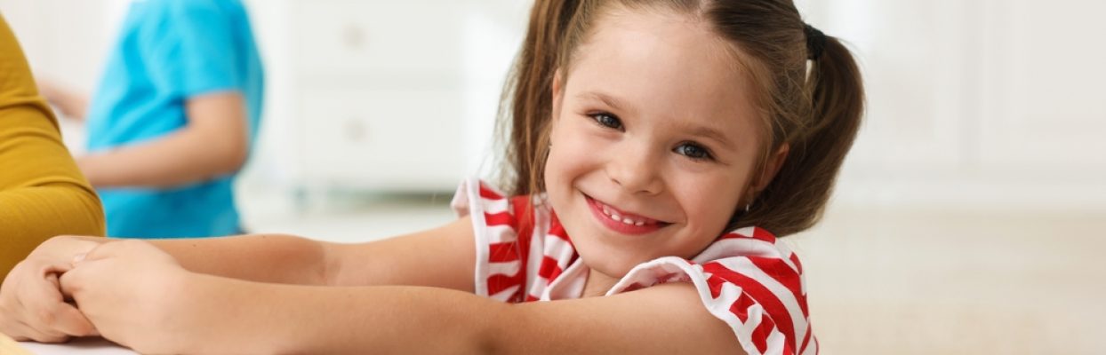 Portrait,Of,Smiling,Little,Girl,At,White,Table,During,Lesson